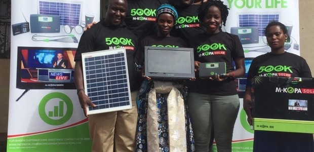 Dorothy Nabawesi,the 500,000th customer displays her M-KOPA solar TV after