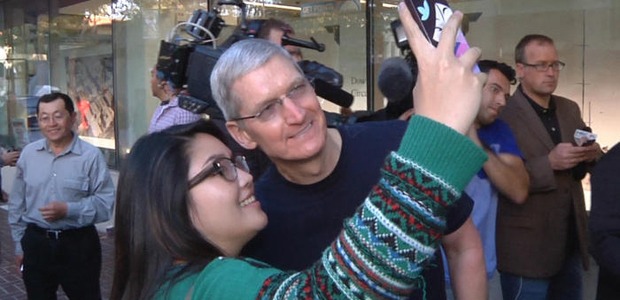 Tim Cook poses for a selfie with a customer outside