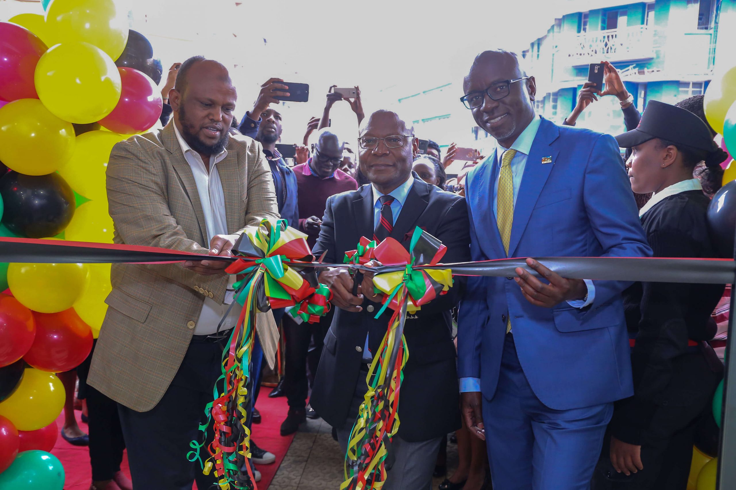 Safaricom Director for Strategy Joseph Ogutu (centre) cuts the ribbon