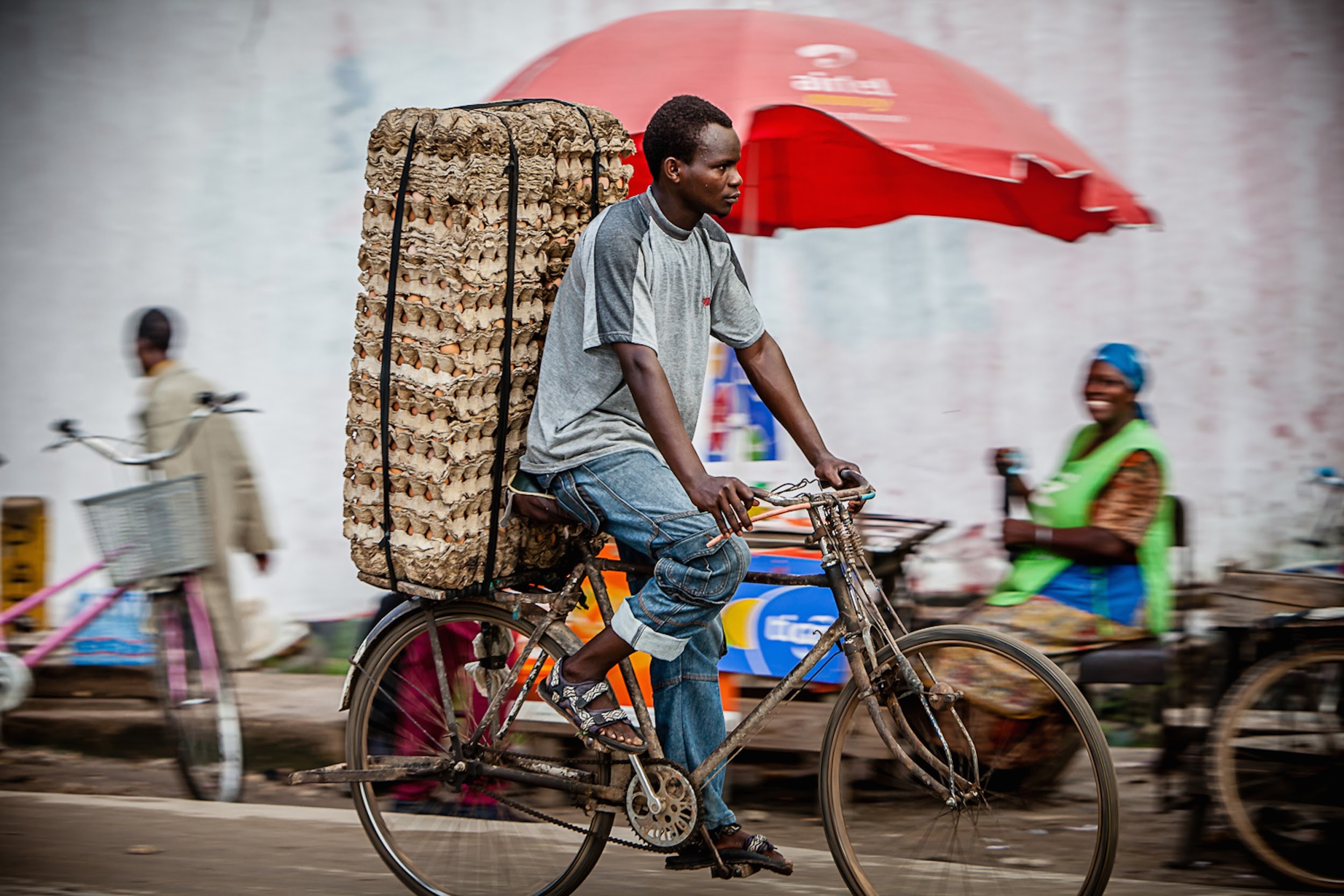 A man rides a bicycle on a market road in