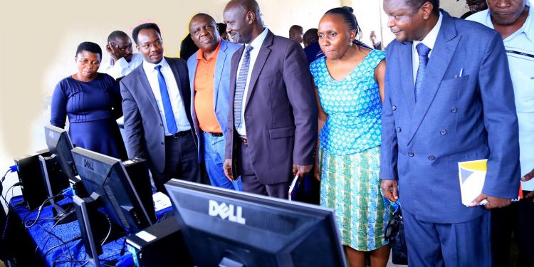Tullow officials hand over computers to Schools in Hoima District