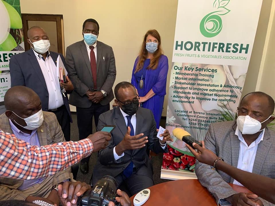 Odrwek Rwabwogo addressing the media in the company of Hortifresh officials at their Kampala Serena based office recently, as Hon Bwiino Kyakulaga, state minister for Agriculture (Right) listens