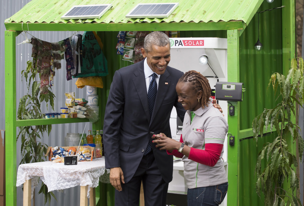 Former US President Barrack Obama looks at an M-KOPA project during his visit to Kenya.