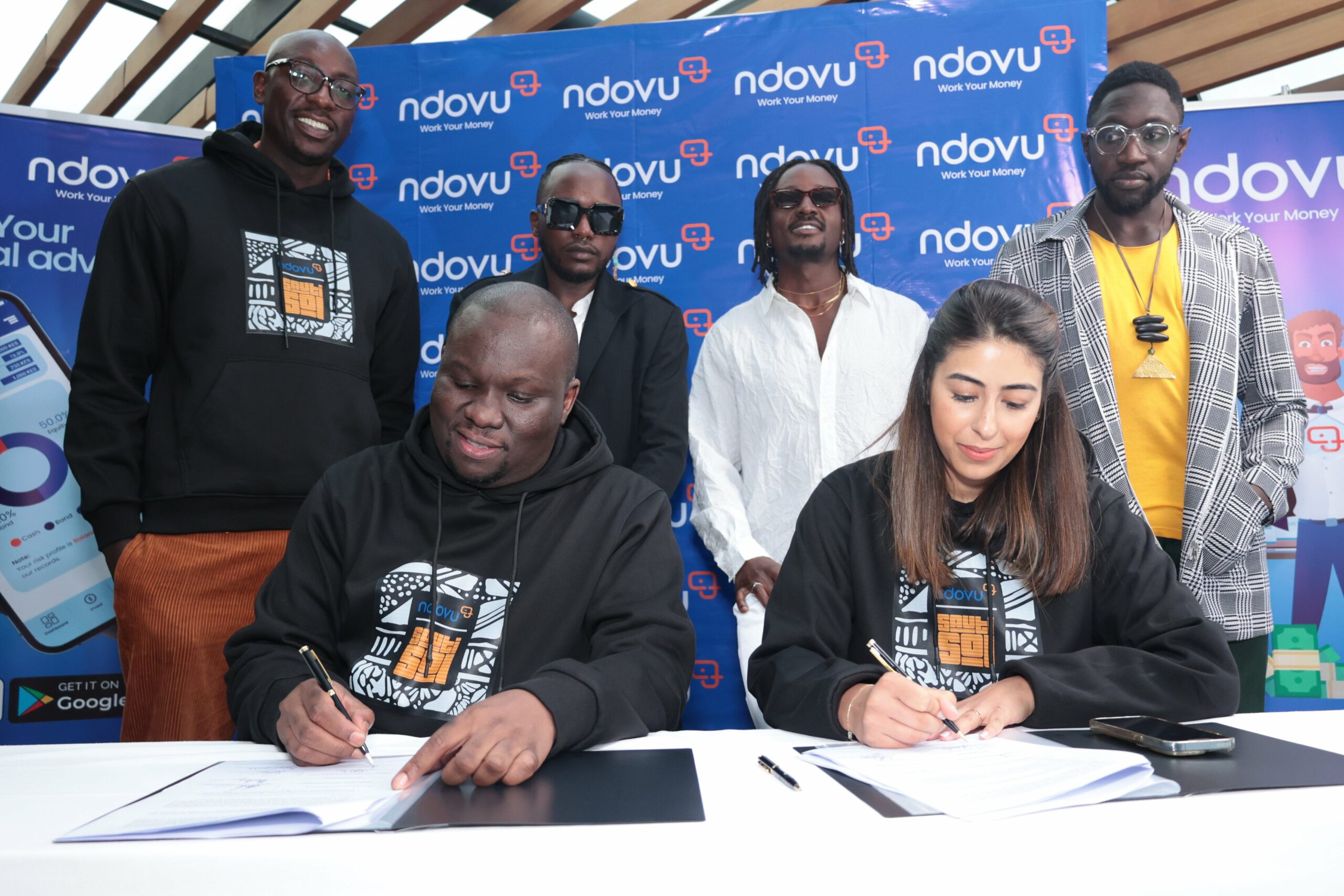 The Sauti Sol and Ndovu team putting pen to paper on their partnership to promote financial literacy and drive financial inclusion in Africa.