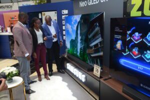 Samsung Head of Consumer Electronics Division Sam Odhiambo (Left) explains the featured of the 2022 Samsung Neo QLED TV to Quickmart LTD’s Consumer Electronics Category Manager Josephine Kariuki (Centre) looking on is Samsung Product Manager Eric Otieno (Right)