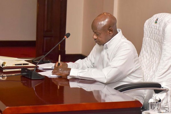 President Museveni signing various laws at State House recently