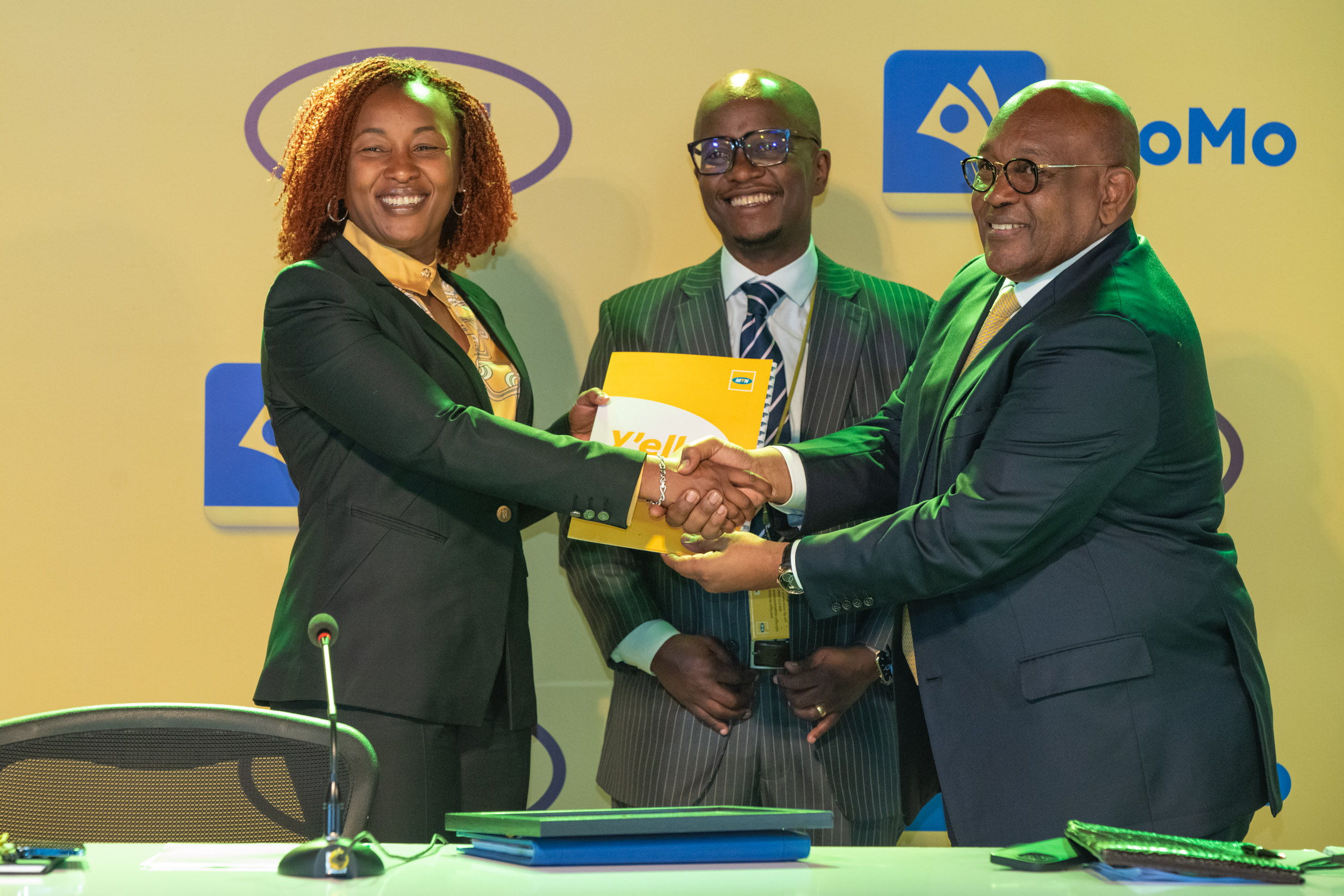 The New MTN Uganda CEO, Sylvia Mulinge (L) receives tools of office from the Board Chair, Charles Mbiire (L). (C) is the MTN Uganda CFO, Andrew Bugembe