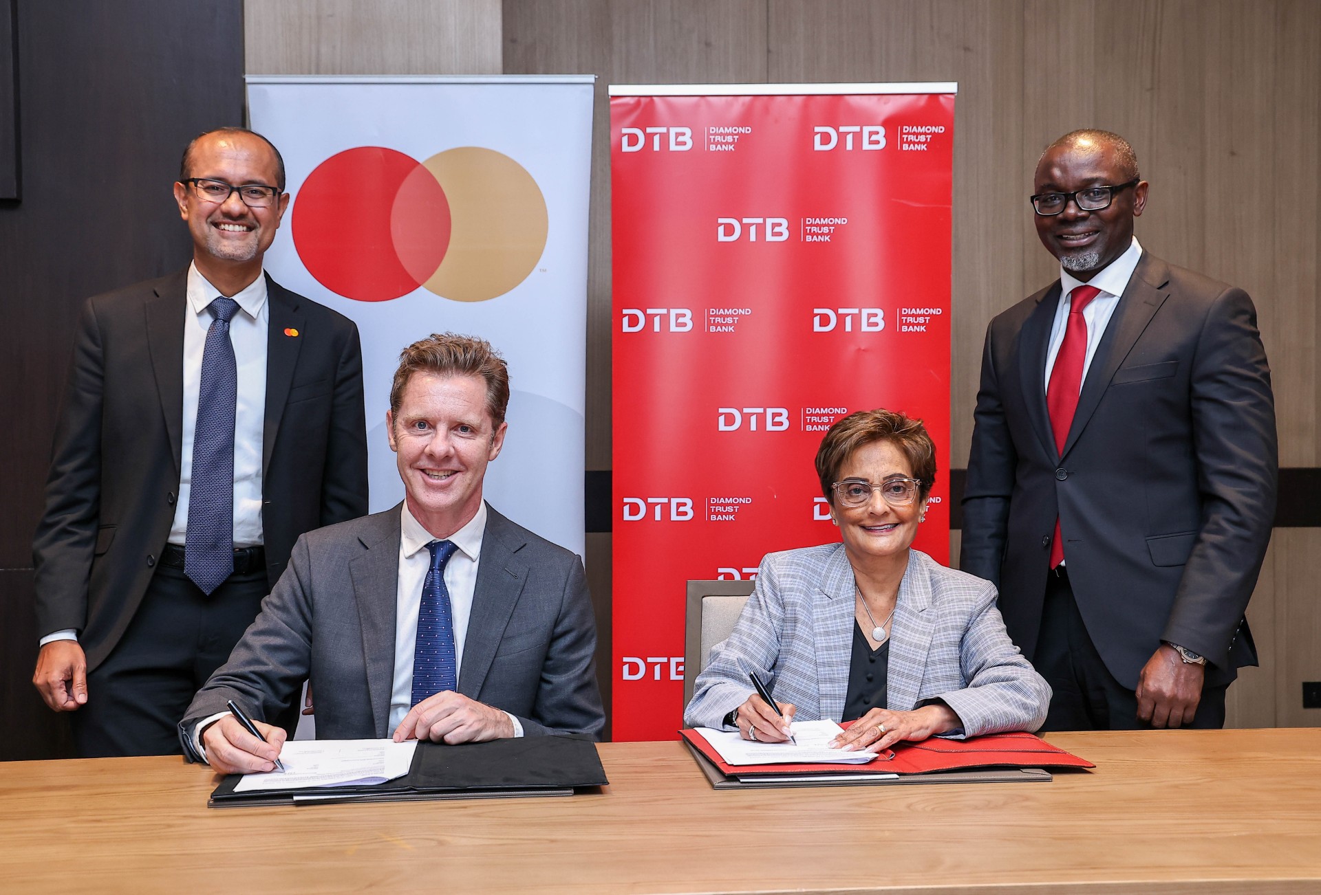 L-R: Shehryar Ali, SVP and Country Manager for East Africa & Indian Ocean Islands at Mastercard; Mark Elliott, Division President for Africa at Mastercard; Nasim Devji, Group CEO at Diamond Trust Bank (DTB); and George Otiende, Director for Retail Banking at Diamond Trust Bank (DTB) during the signing of a landmark 10-Year agreement that will dive digital transformation in Kenya, Uganda and Tanzania.