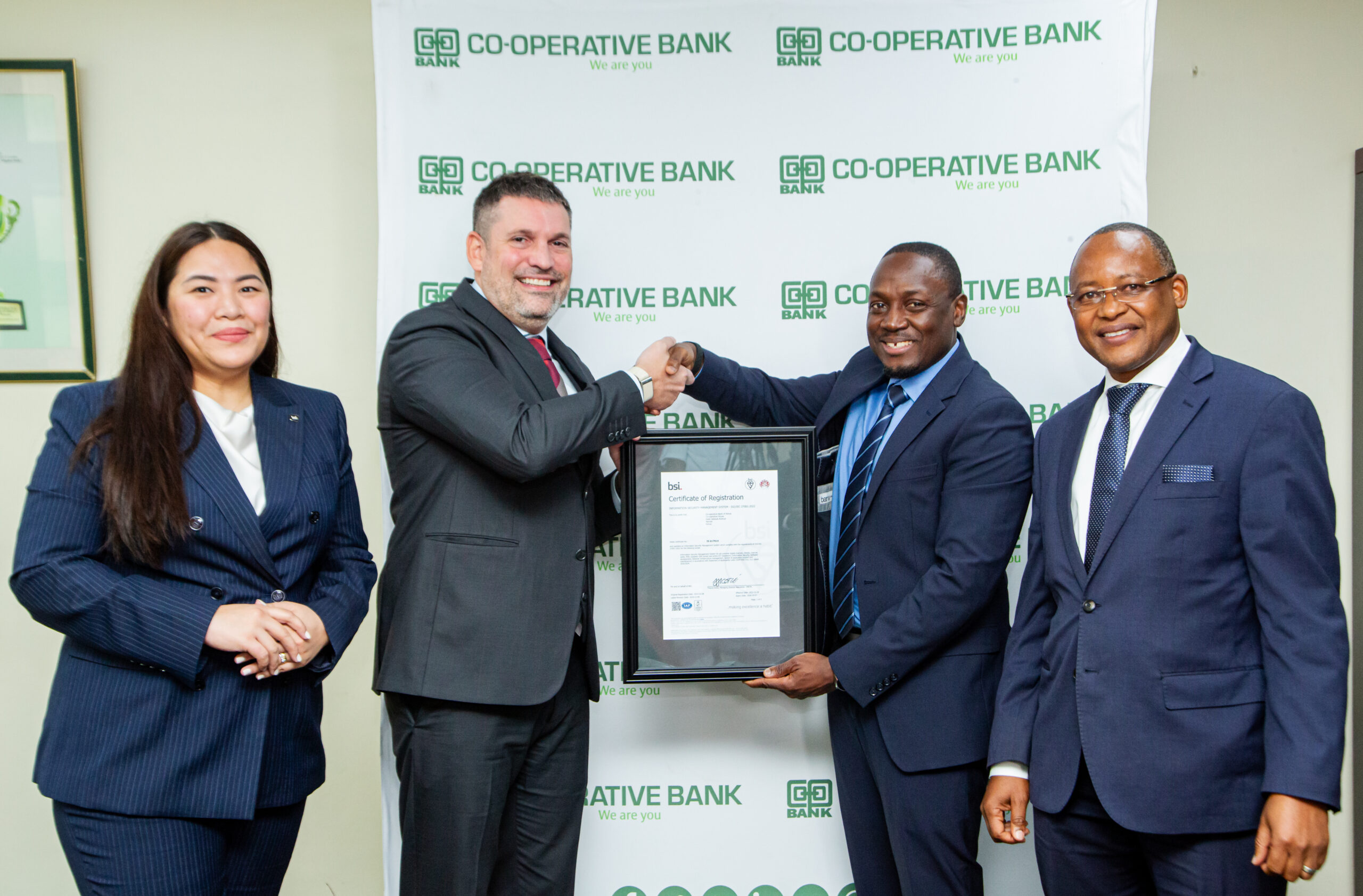 Ilias Karampoikis, Regional Director, BSI, and Darlene Cueto-de Visscher, Key Account Manager – BSI, present the ISO 27001:2022 Certificate to Charles Washika, Director ICT & Innovations Division, and James Kaburu, Chief Risk Officer, Co-operative Bank, during the handover ceremony at Co-op House.